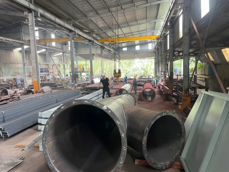 Xưởng cơ khí với ống thép lớn, thép hình và cầu trục chờ tháo dỡ để di dời